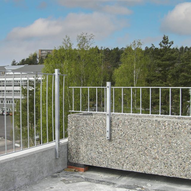 Lavt metallrekkverk som forhøyning på mur.