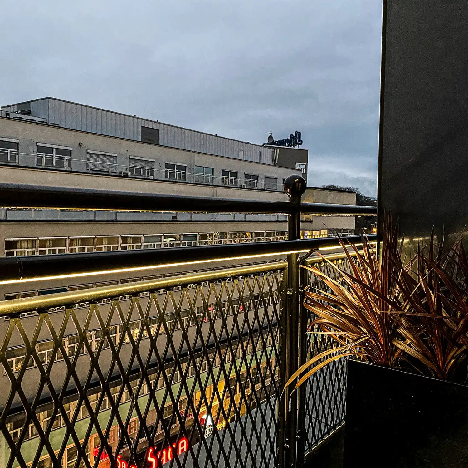 Lakkert flettverksgjerde med lys på Hotel Continental.