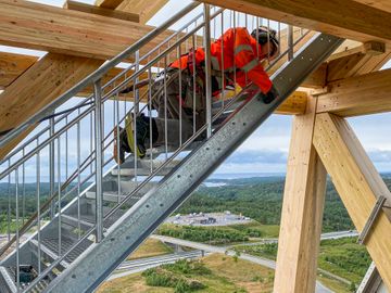 Bilde av montør som jobber høyt over bakken med trappa til klatre- og utkikkstårnet OVER i Lillesand.