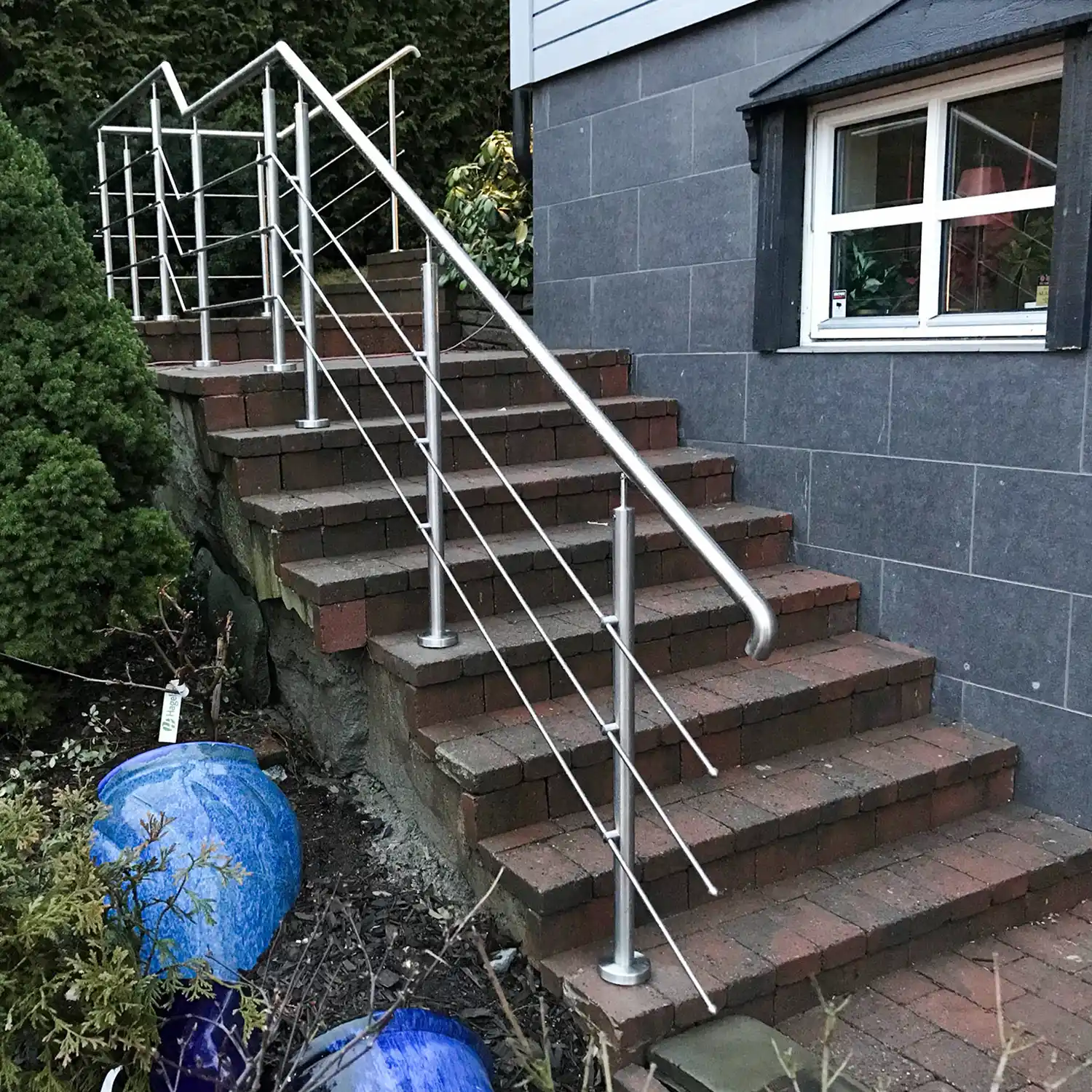 Rustfritt rekkverk i trapp med horisontale spiler.