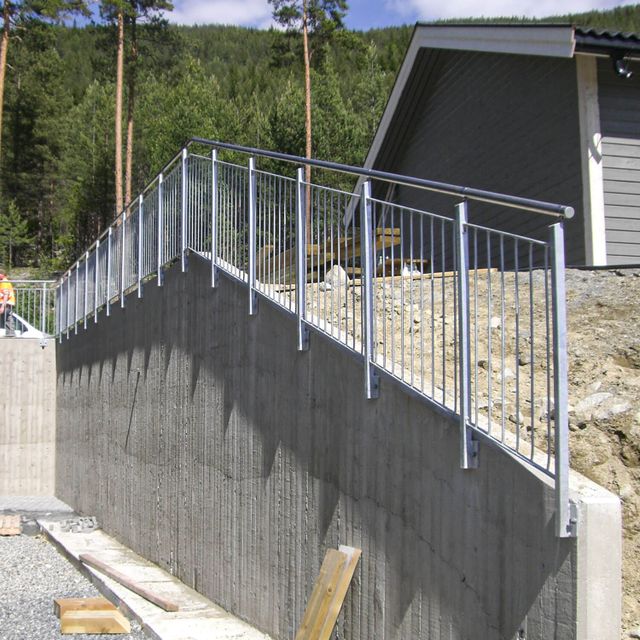 Rekkverk på mur med vertikale spiler.