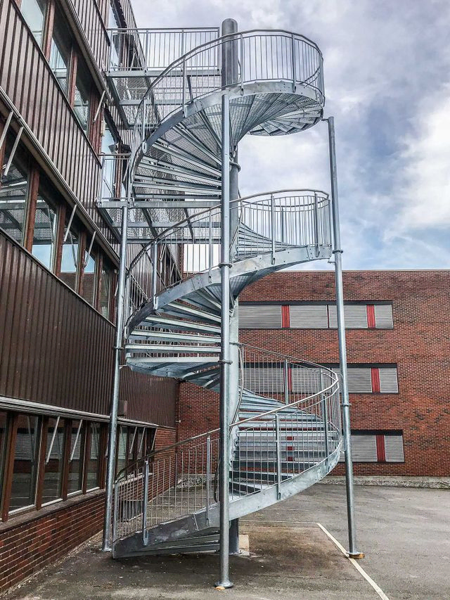 Bred utendørs spiraltrapp med repos. 