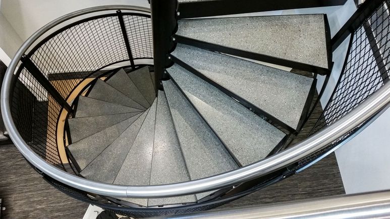 Bilde av innendørs spiraltrapp med betongtrinn.