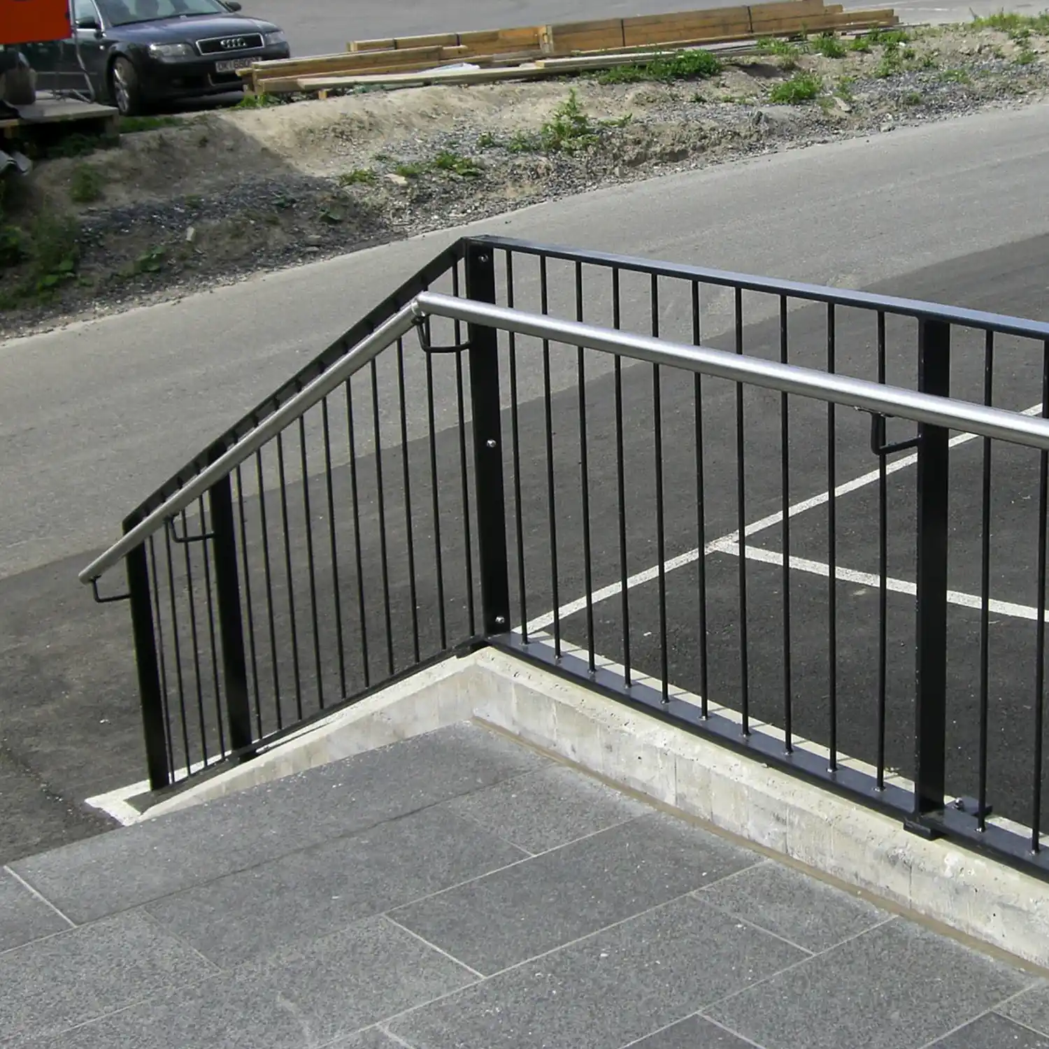 Lakkert trapperekkverk ute med vertikale spiler og håndløper..