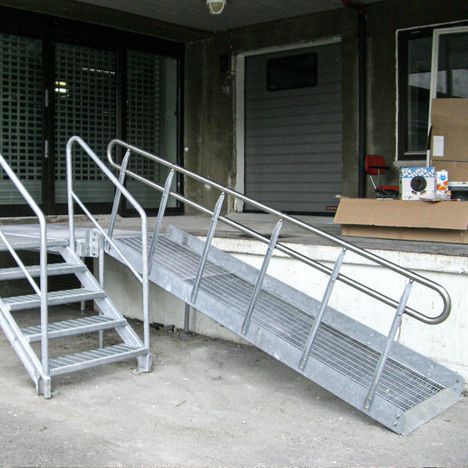 Lasterampe med trapp og rullestolrampe.