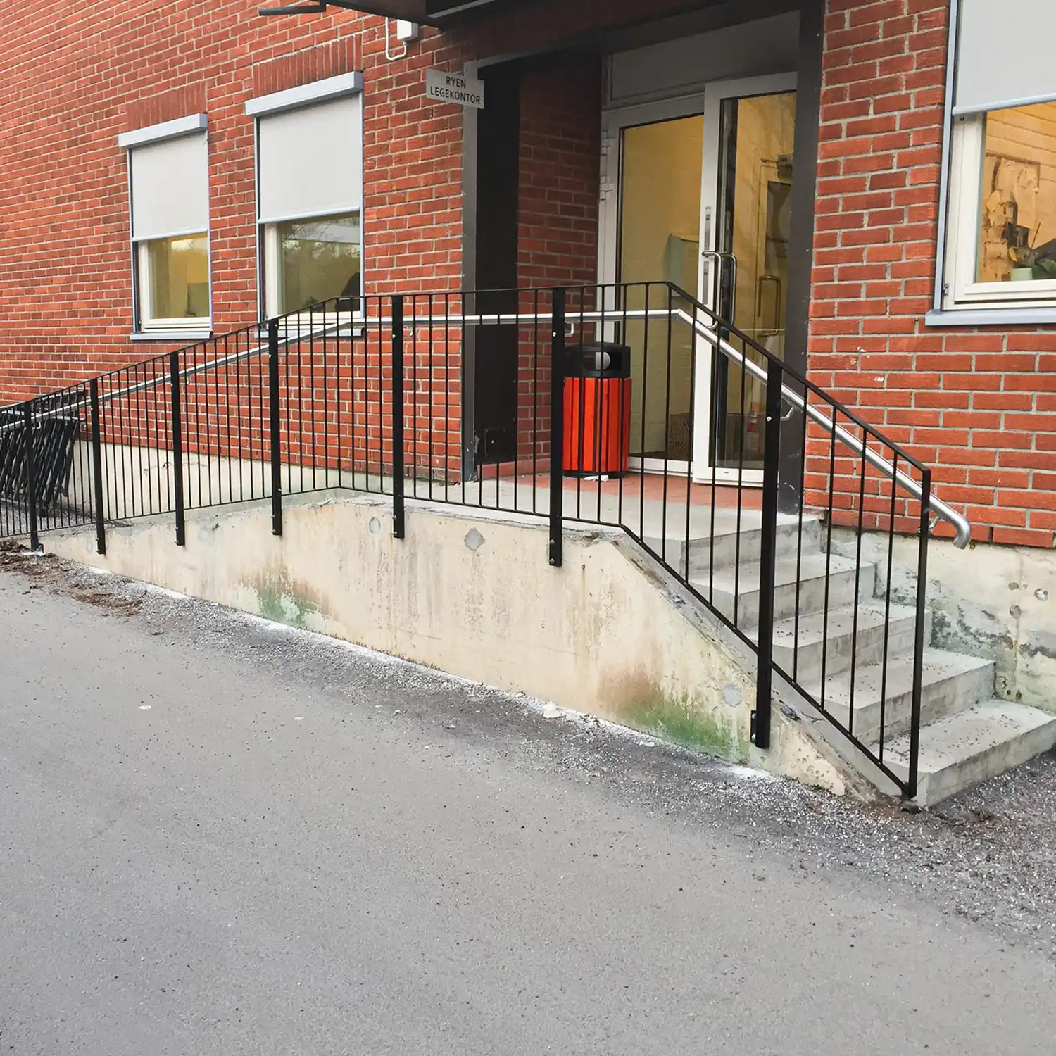 Lakkert trapperekkverk ute med vertikale spiler og håndløper..