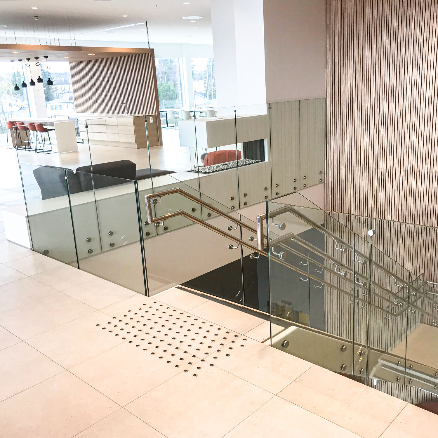 Bilde av glassrekkverk i trapp innendørs.